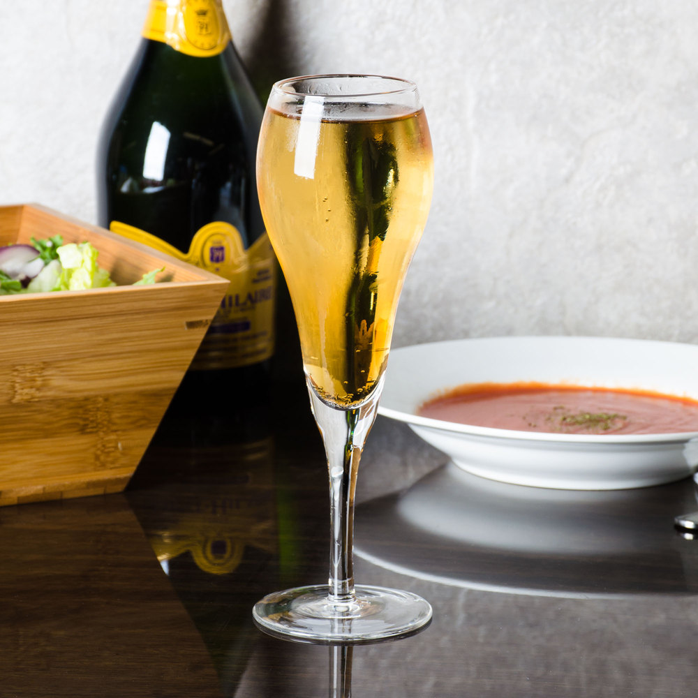 copas de champagne tipo tulipa sobre mesa de cristal fondo blanco